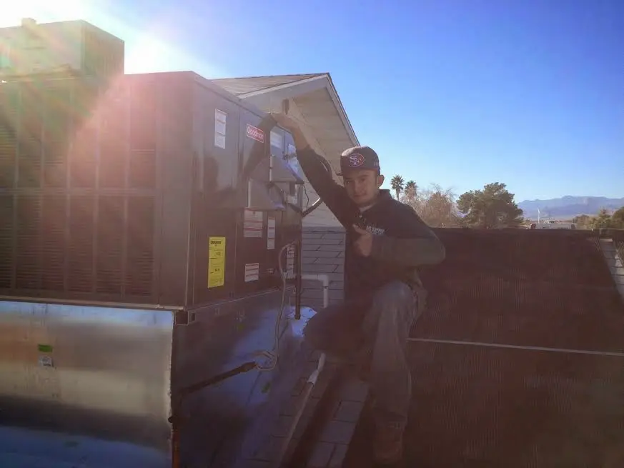 HVAC technician performing AC Tune-Up on a rooftop unit in Spring Lake