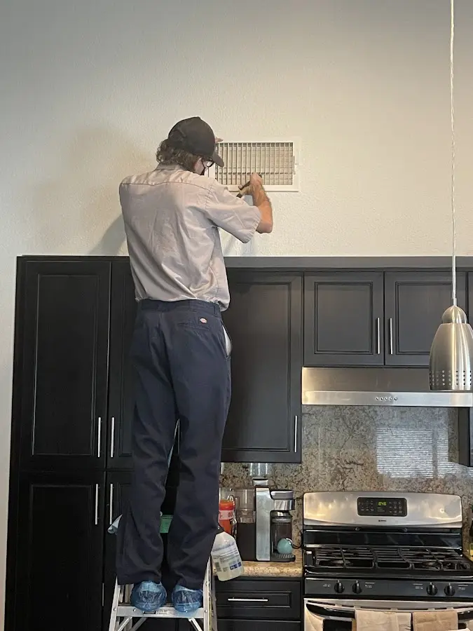 Technician inspecting an air vent during HVAC service in Spring Lake